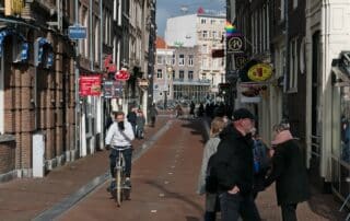 Livlig stadsgata med cyklister och fotgängare.