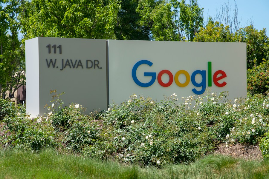 Google-skylt med adress omgiven av grönska.