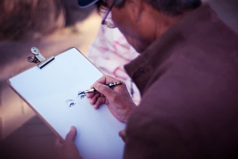 Person tecknar ett öga på papper.
