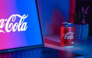 Coca-Cola burk bredvid laptop med logga