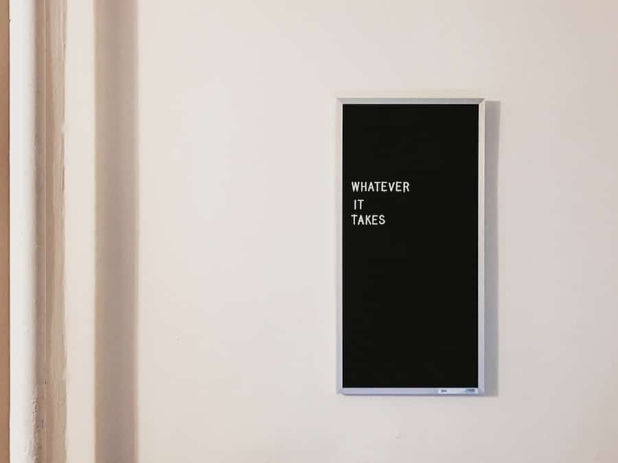 Svart tavla med texten "WHATEVER IT TAKES" på vägg.