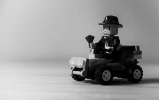 Lego-figur i hatt kör leksaksbil.