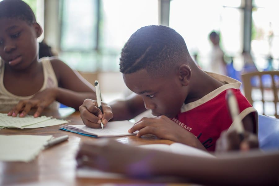 Barn fokuserat skriver i klassrum.