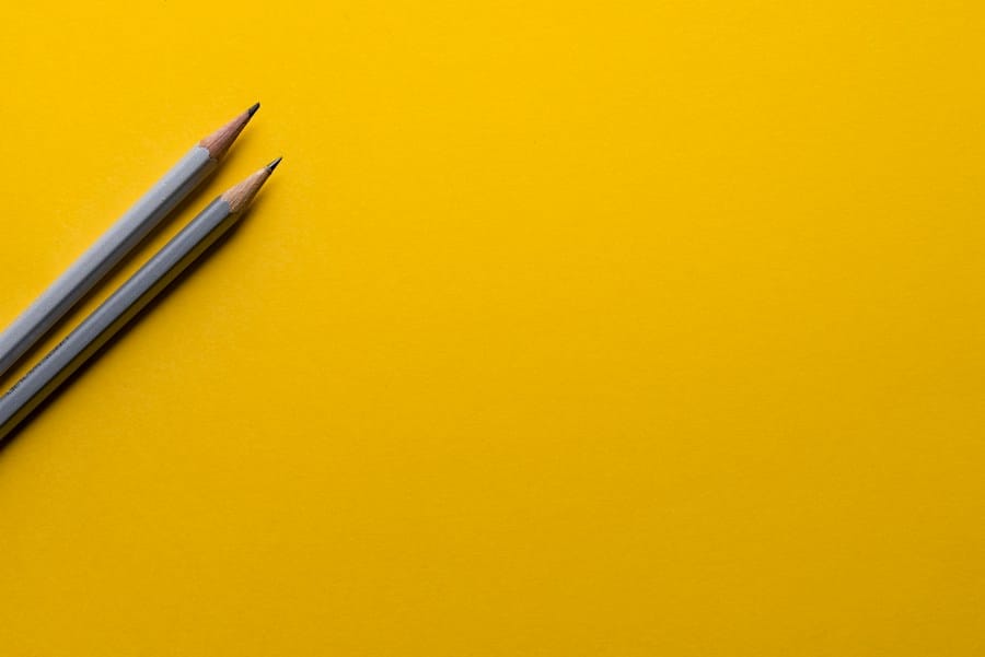 Två blyertspennor mot gul bakgrund.
