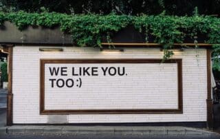 Växtbeklätt skyltfönster med texten "WE LIKE YOU TOO:)".