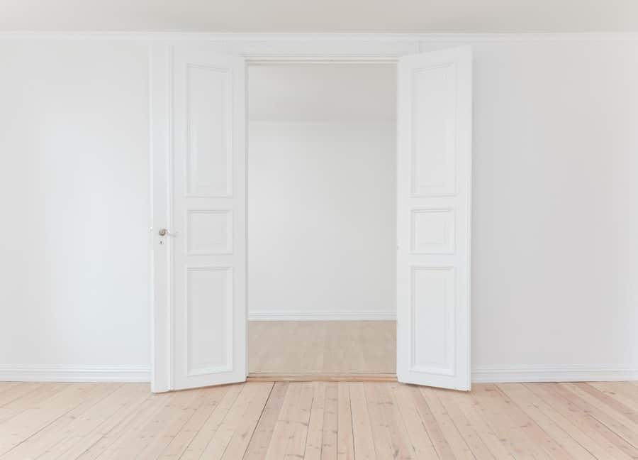 Öppna vita dörrar till tomt rum.