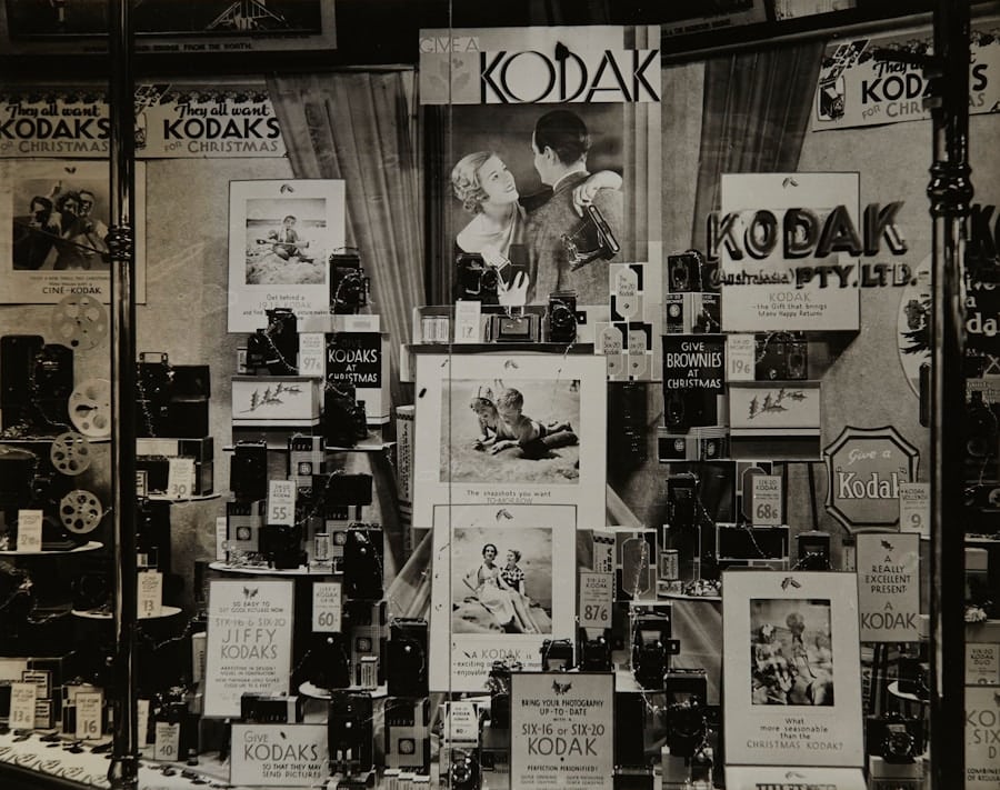 Gammal affärsdisplay med Kodak-kameror och reklam.