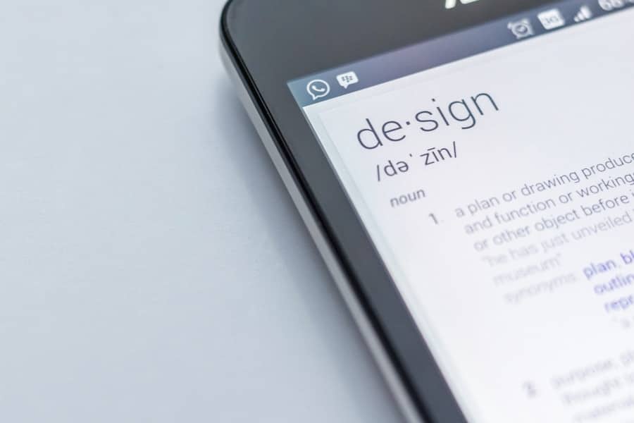 Smartphone visar ordet "design" på skärm.